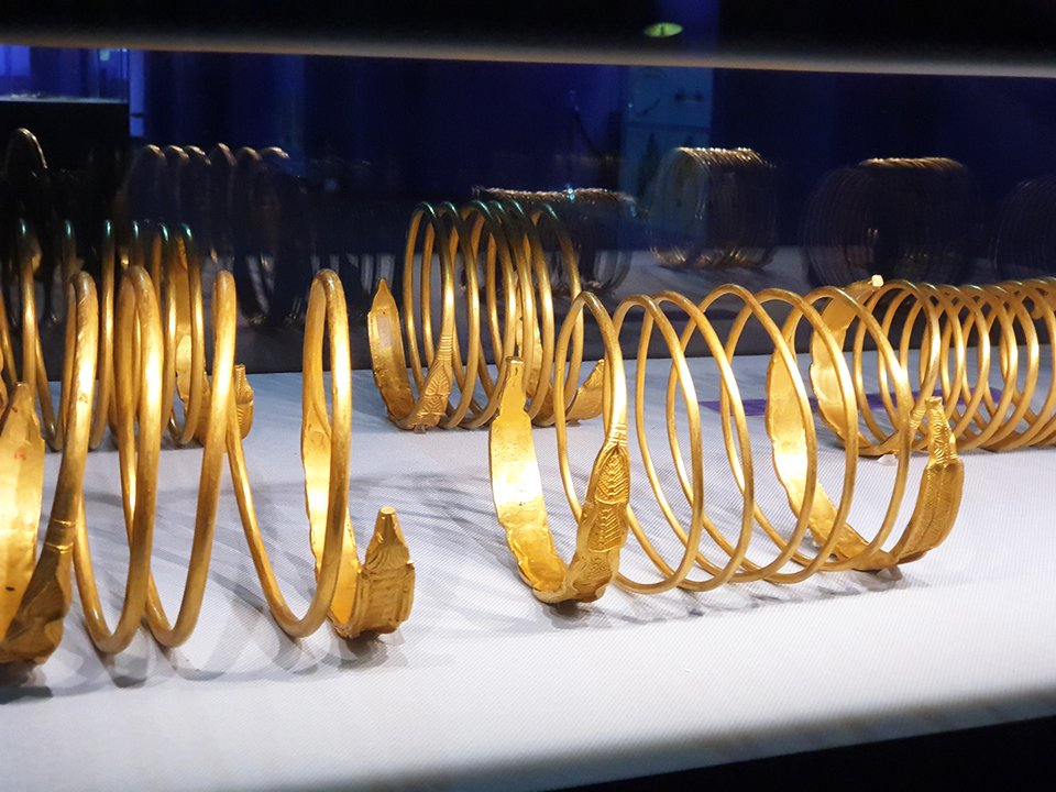 Suprafața Sarmizegetusei este o iluzie; practic, artefactele și monumentele sale sunt ca piese de șah care au fost mutate pe o tablă în carouri. Oricum, originile și adevărata sa semnificație sunt ascunse adânc sub pământ. În plus, fiecare civilizație este stratificată peste predecesorii săi; cu cât săpăm mai adânc, cu atât originile noastre sunt mai antice. Deci, trebuie să ne întrebăm cine a existat acolo înaintea traco-geto-dacilor și cine erau zeii lor? ce s-a descoperit în timpul săpăturilor arheologie? De exemplu, în anul 2000, a fost găsită una dintre cele mai decisive descoperiri din istoria dacilor geți: 15 brățări de aur la Sarmizegetusa care au zguduit temelia istoriei României. Aceste brățări erau minereu de aur extras din munții Carpați, Roșia Montană și regiunea Sarmizegetusa. În plus, am menționat de mai multe ori că Sarmizegetusa era o operațiune minieră și un observator astronomic. În concluzie, dacii au asamblat o armată puternică, construind fortificații în toată regiunea pentru a proteja comoara depozitată la Sarmizegetusa, și practicile lor religioase.Mai mult, geto-dacii au creat un sistem foarte avansat de extragere a minereului de aur pe care nu îl putem replica astăzi din punct de vedere tehnic sau alchimic. În cele din urmă, aurul a fost amestecat cu o cantitate mică de argint pentru a spori culoarea și rezistența brățărilor; geto-dacii erau maeștri ai alchimiei, un dar primit de la zei.Putem vedea acest concept de arhitectură ezoterică în construcția orașului geto-dac, pe care acum îl numim cele 9 sanctuare și cetăți dacice supraviețuitoare: Apulon, Sarmisegetuza Regia, Costești, Blidaru, Fetele Albe, Piatra Roșie, Bănița, și Căpâlna; toate așezate într-o aliniere cu muntele lor sacru, Godeanu (Godeanu reprezintă locația a ceea ce mulți cercetători consideră că este misteriosul „Kogaion”). Fiecare dintre aceste locații corespundea unui nivel de inițiere în care fiecare elev experimenta cunoașterea vechilor arieni și a lui Zamolxis. La absolvire, adepților li s-ar fi acordat o brățară în formă de dragon. Aceste brățări erau diplome; fiecare model includea inscripția unui scut și o creastă care ar simboliza o stemă. Numărul de creste și lungimea spiralelor de pe brățară ar identifica gradul de cunoaștere al individului, obținut de la ordinul dragonului și școala misterului Zamolxian. Regele Burebista, care a fondat acest sistem în munții Orăștiei, a făcut acest lucru pentru o eficacitate optimă; a vrut să păstreze totul localizat și cuprins cu orașul Dacia. Prin urmare, Munții Orăștiei și văile lor au fost cea mai abundentă si satisfăcătoare locație astronomică pentru construirea rețelelor și sistemelor de temple și fortărețe.Zamolxis este punctul intermediar sau Stația de Transfer pentru toate energiile universale, „Controlul Volumului” .Acest sistem este pus în aplicare pentru alinarea conștiinței în organismul nostru. Astfel, Zamolxis a fost versiunea a ceea ce acum numim rai. Anticii își investeau timpul pe pământ aducând-ul jos pe Zamolxis; priveau cerul nopții și construiau constelații în arhitectura lor pentru a-i atrage sau a pentru a fi aproape de zei.